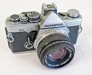 Olympus The 35 mm film-based Olympus OM-2 (1975), which was the first SLR to measure light for electronic flash off the film plane.