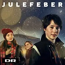 A photograph of three children appear, one boy and two girls. Behind them is a large, white tent against a night-scape background. The image also contains the words "Julefeber, DR" in an all-caps, white font.