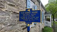 a picture of the marker, with the old stone building behind it