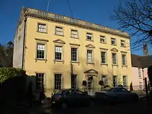 Three-storey yellow-coloured house in the Palladian style