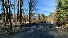 a paved road ends abruptly at a river