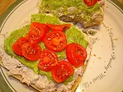 Open-faced tuna sandwich with guacamole and cherry tomatoes