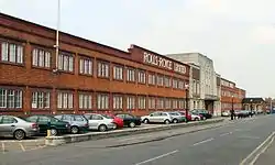 Image of a red brick building with a central front door, the words Rolls-Royce Limited appear above the door in white letters