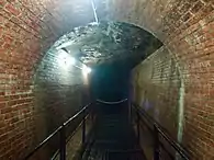 A section of aqueduct with brick walls and exposed ceiling