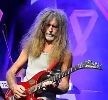 Ota Petřina playing a red electric guitar onstage