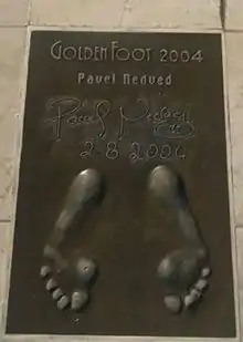 A golden cast of Nedved's footprints. His signature and the date are recorded at the top of the image.