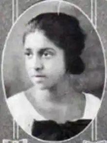 A young Black woman wearing a white dress with a black bow, in an oval frame