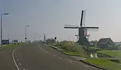 Windmill (de Vrouw Vennemolen) with catholic church in the background