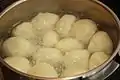 Pan of dumplings in boiling liquid