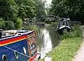 The Oxford Canal, approaching Isis Lock with narrowboats moored by the canal.