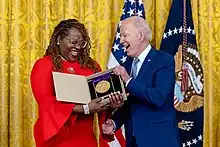 Photo of award ceremony in which President Joe Biden presents the National Medal of Arts to the Billie Holiday Theatre.