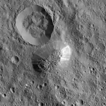 A smooth-sided mountain rising from a grey surface