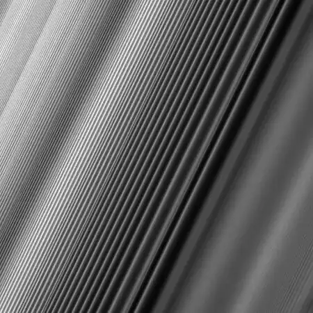 A spiral density wave in Saturn's inner B Ring which forms at a 2:1 orbital resonance with Janus. The wavelength decreases as the wave propagates away from the resonance, so the apparent foreshortening in the image is illusory.