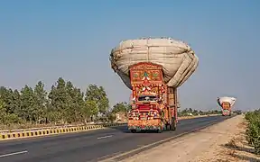 Two decorated trucks on Pakistan's N-5 National Highway.