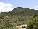 Matorramos Rock in the Serra d'Espadà rising behind olive tree fields