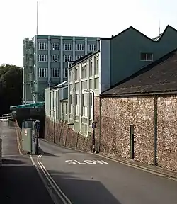 A road leading down a slight incline with buildings on the right