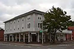 Photograph of a three-story urban building with a large veranda