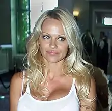 Photograph of a women with blonde hair and a white shirt