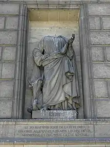 Saint Luke. The statue lost its head to a German shell in World War I.