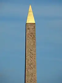 Hieroglyphs on the upper obelisk. The Pharaoh on his throne is portrayed at the top