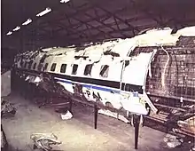 Pieces of aircraft fuselage patched up together, in a hangar