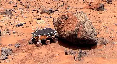 The Sojourner Rover is taking its Alpha Proton X-ray Spectrometer measurement of the Yogi Rock (NASA). Note: Sojourner Rover was the rover part of the Mars Pathfinder. It rolled off of the lander. This picture was taken by the lander.