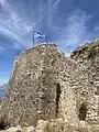 The Greek flag flying from the highest point in the fortress.