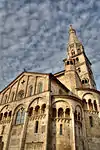 A white stone church with one tall tower.