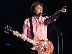 McCartney points to the audience while performing on stage.