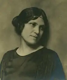 Woman in 3/4 profile wearing a flapper-style dress and headband
