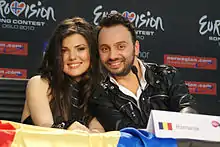 A man and a woman sitting at a table and smiling at the camera.