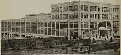 A monochromatic image of a large shopping arcade behind a viaduct