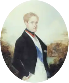 A painting depicting a light-haired young man standing in profile with head turned toward the viewer and wearing a black cutaway coat, white vest and white trousers with a blue sash of office over the vest and the Order of the Golden Fleece suspended on a red ribbon around his neck