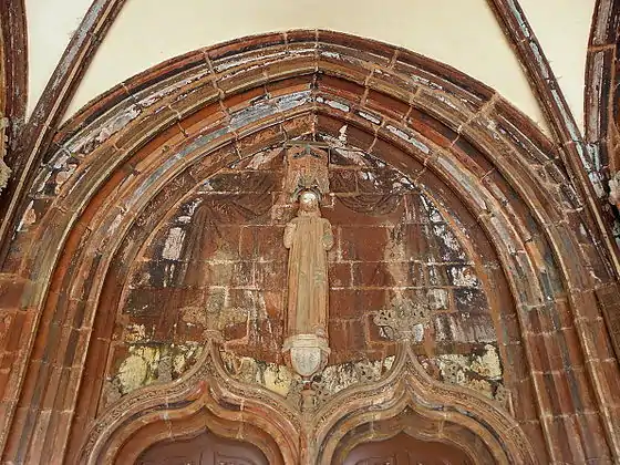 The sculpture in the porch interior and above the double entrance doors to the church