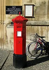 A Victorian hexagonal red post box of the Penfold type manufactured in 1866 outside King's College, Cambridge (not the original location for this box).