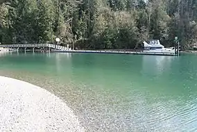 Motorboat at a dock with a forest on the shore