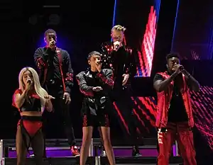 A color photograph of a cappella group Pentatonix performing live in 2018.