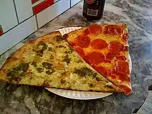 Slices of New York–style pizza, chicken pesto on the left, pepperoni on the right