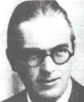 middle-aged white man, clean shaven, receding hairline, bespectacled