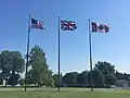 Flags of Canada, the U.S., and the U.K. fly next to the memorial at equal height.