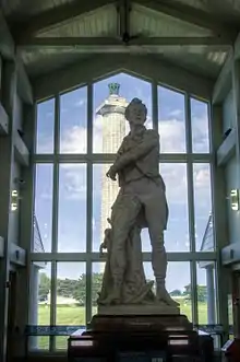The memorial column can be seen from the visitor center behind a statue of Commodore Perry.