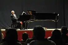 Hicks playing a grand piano onstage