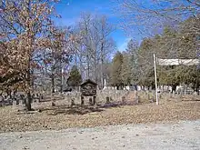 Backside of the cemetery, with a visitor's sheet available in the wooden structure