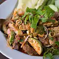 Phla nuea makhuea on is a Thai salad of medium rare beef and nearly raw sliced Thai eggplant