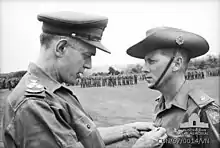 Major Harry Smith of St. John's Wood, Brisbane, Qld, receiving the ribbon to the Military Cross for gallantry from Brigadier O. D. Jackson.