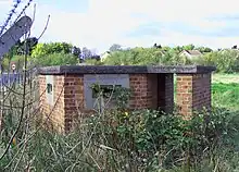 Low-slung reinforced brick gun emplacement, with two long horizontal gun-slit windows