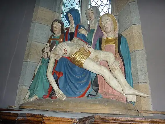 "The descent from the Cross". A 15th-century polychromed woodcarving. The Virgin Mary is supported by a female saint as the dead Christ lays across her knees. At her side is John the Evangelist and Mary Magdalene.