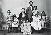 Photograph of Pontic Greek man, woman, and their children. The man is dressed in Western clothes, the woman in traditional costume.