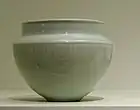 A blue-grey bowl with a nearly perfect half sphere body, and a rim that narrows from the edge of the half sphere, then goes up slightly.