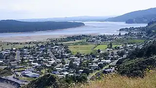 A view overlooking the Port Waikato township. The Waikato river is visible in the background with forestry on the opposite bank.